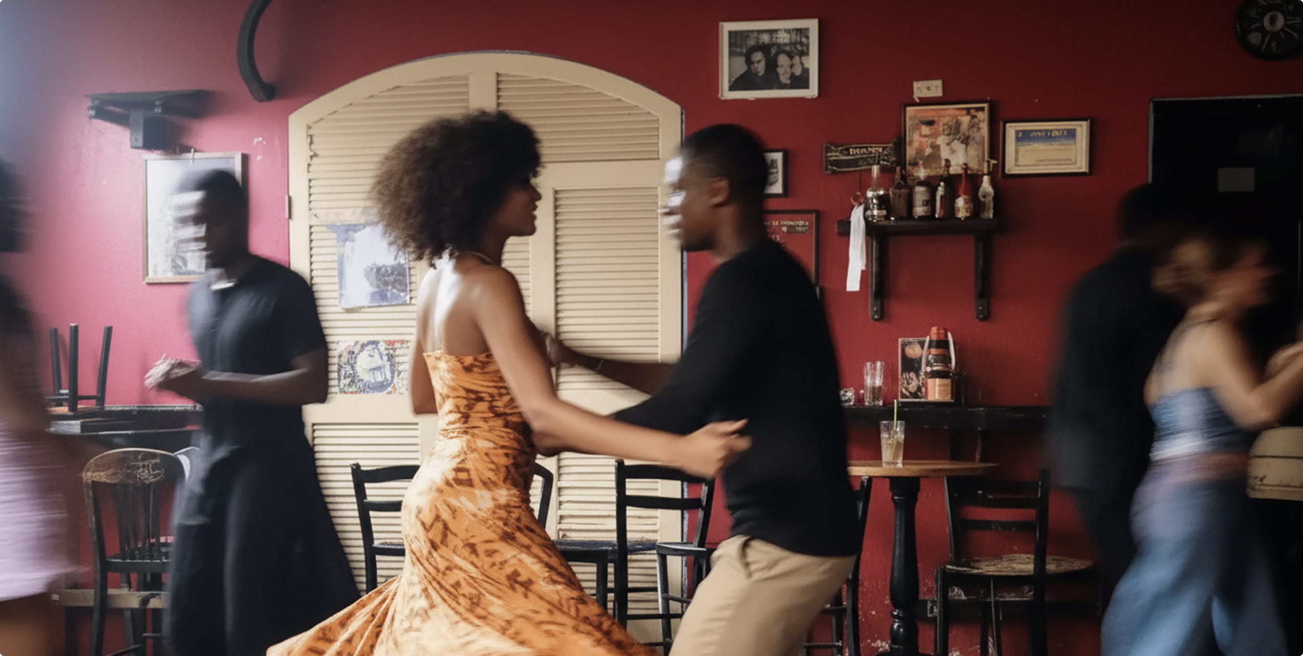 A man and a woman engage in a dynamic dance pose against a colorful mural background.
